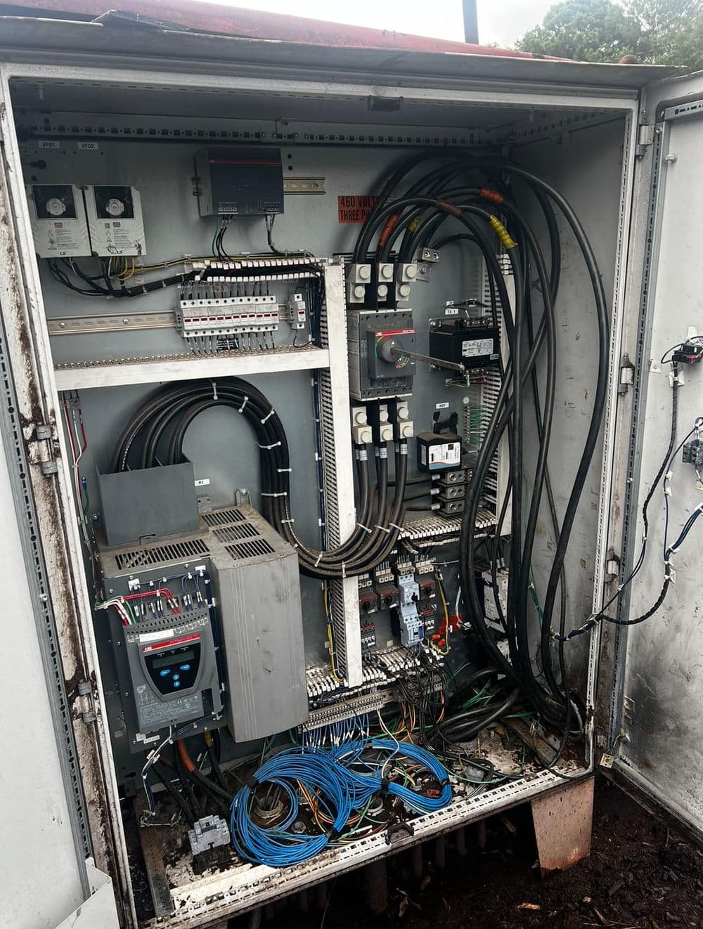 Electrical control panel with wiring and components for automation systems, inside a metal enclosure.