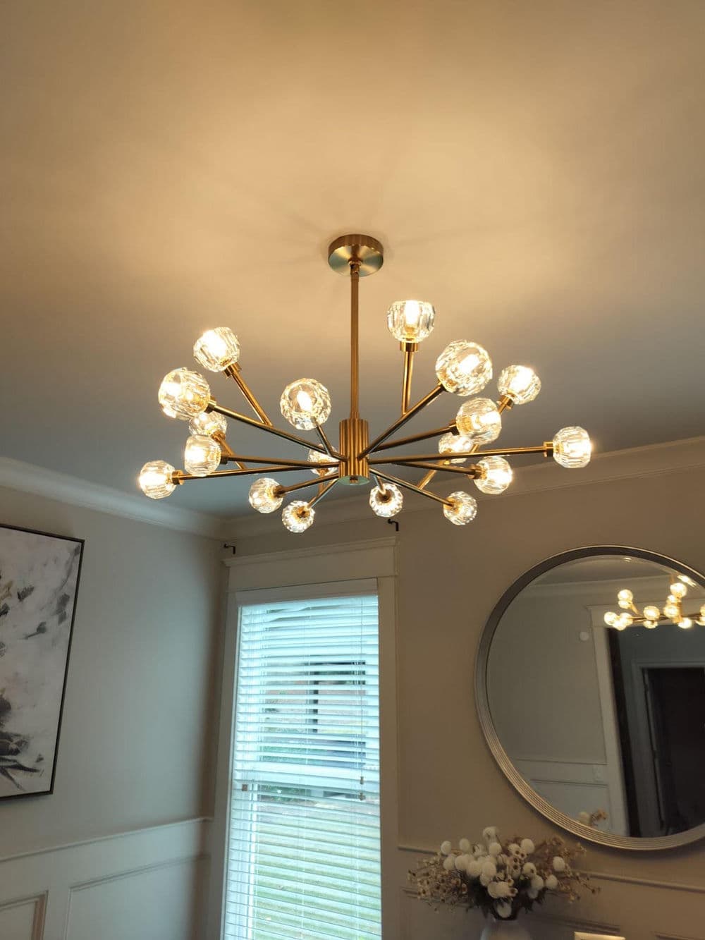 Modern brass chandelier with multiple glass globes, illuminating a stylish room interior.