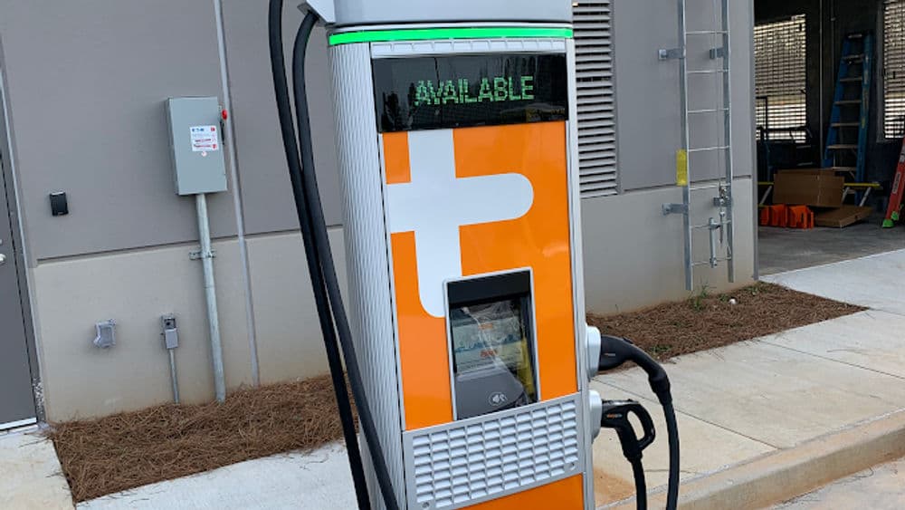 Electric vehicle charging station with green "Available" sign, ready for use.
