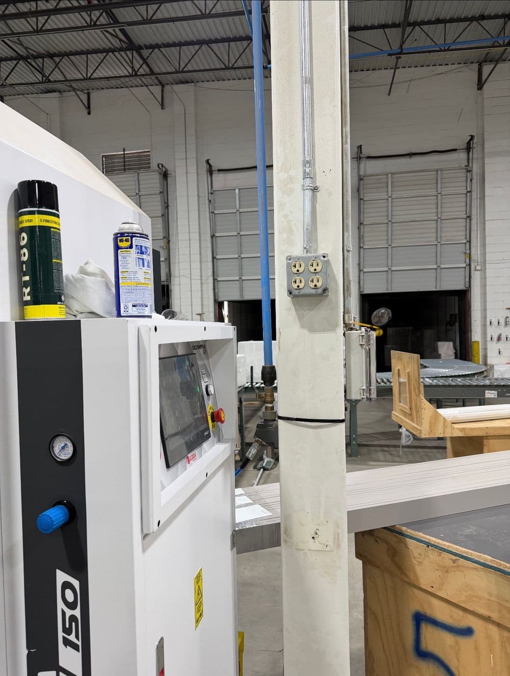 Industrial workshop with equipment, power outlets, and machinery for manufacturing processes.