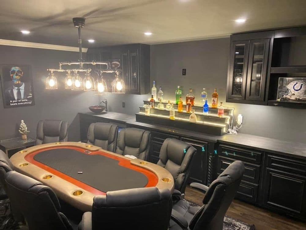 Stylish home poker room with a sleek table, comfortable chairs, and well-lit bar area.