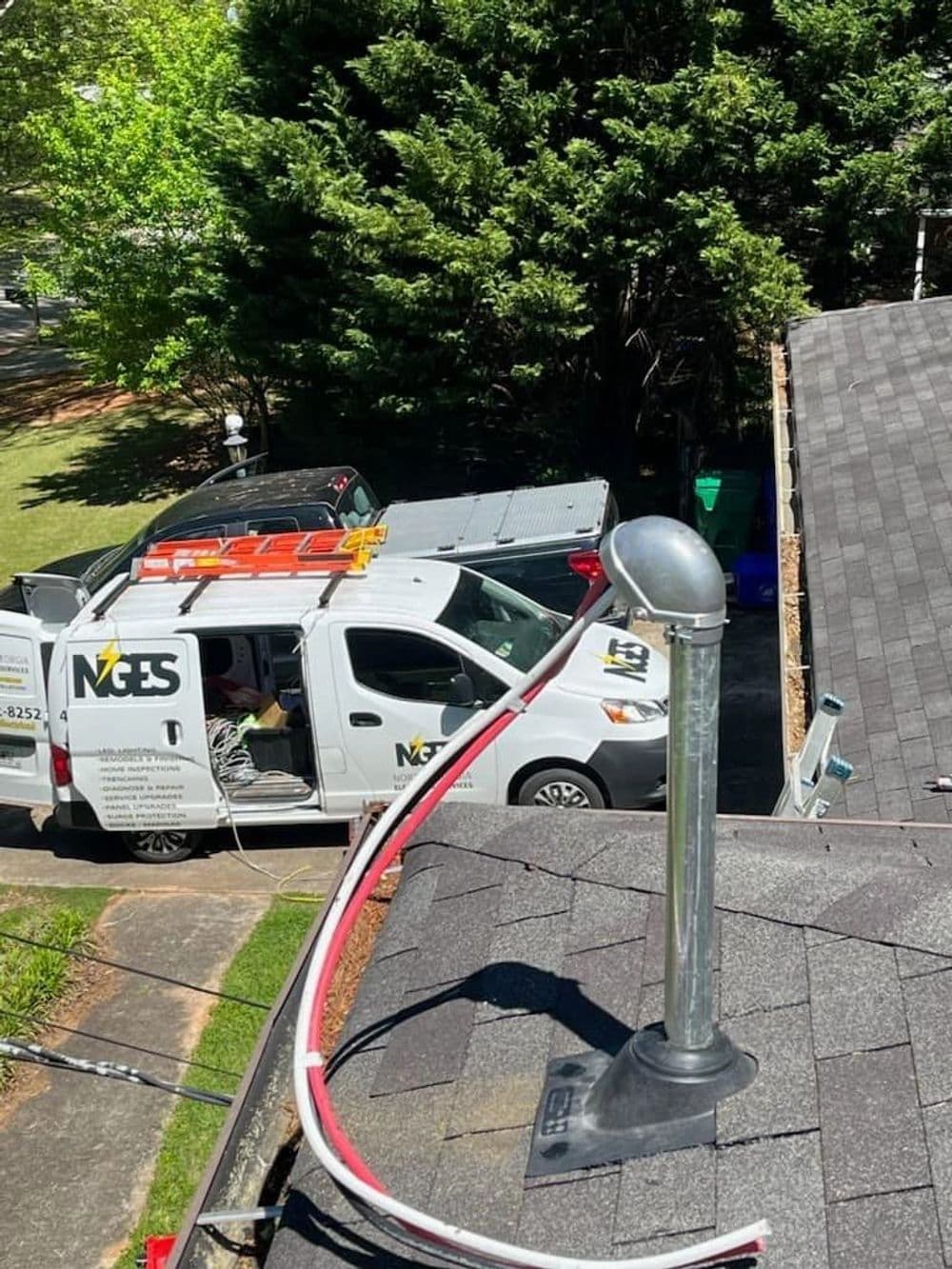 Roof maintenance with a service truck and vent pipe visible in a residential area.